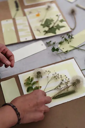 Persona elaborando una cianotipia en nuestro taller con elementos naturales